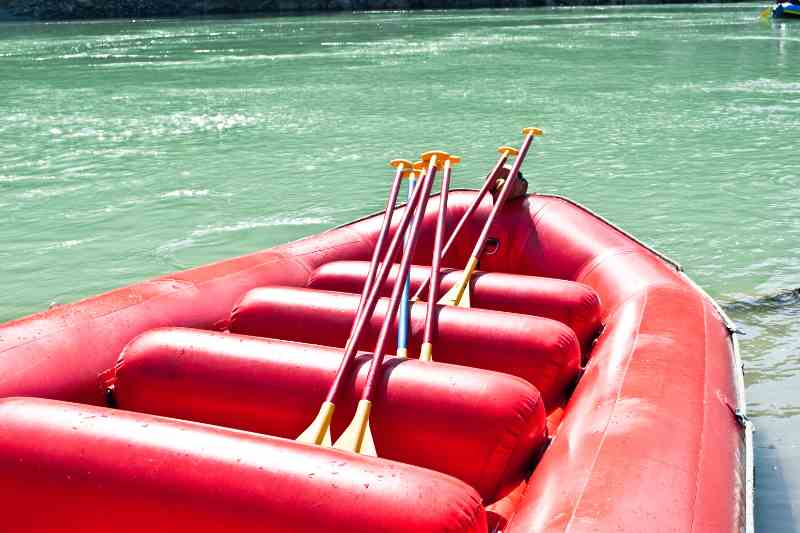 Bote vermelho vazio em rio de aguas azuis.