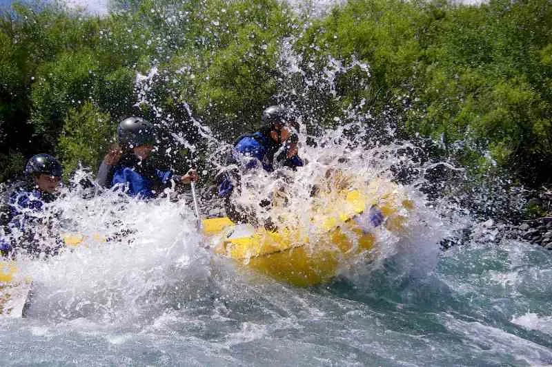 Praticantes de rafting enfrentam águas movimentadas em seus botes.