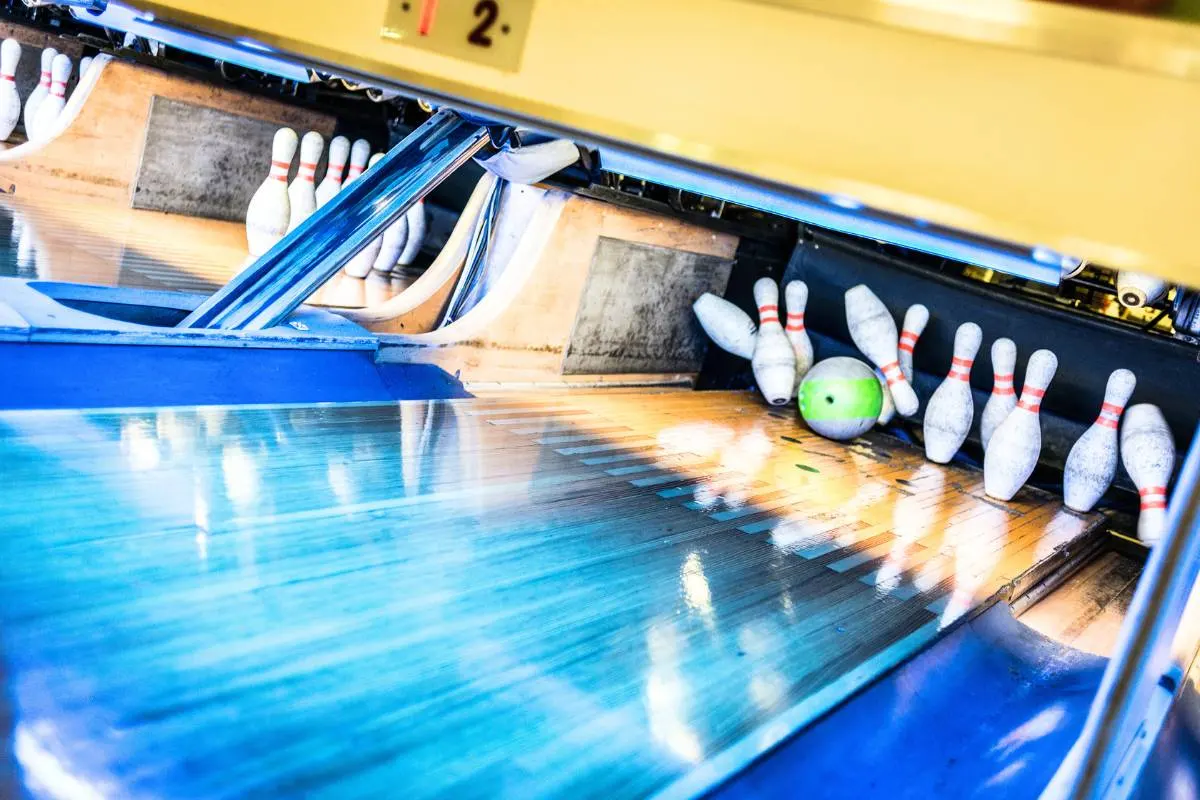 Pista de boliche com pinos derrubados e bola. Competições de Boliche no Brasil.
